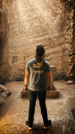 See The World Tee lifestyle photo in a cave, back view